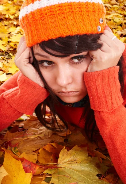Girl in orange hat on leaves. Autumn depression.