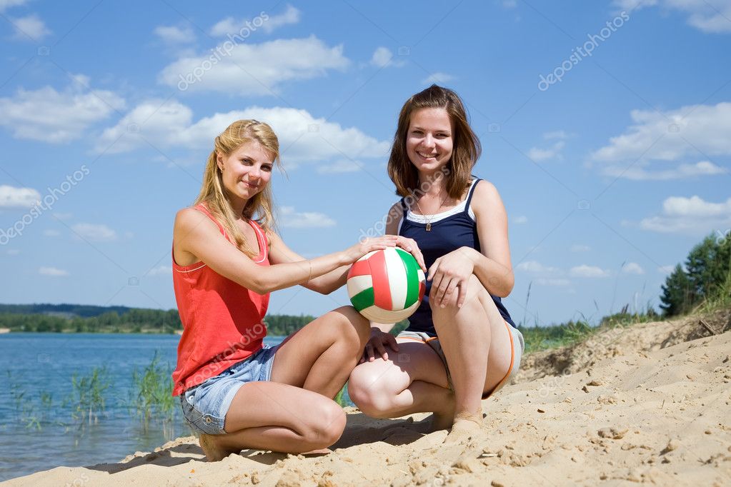 Young girls posing with volleyb...