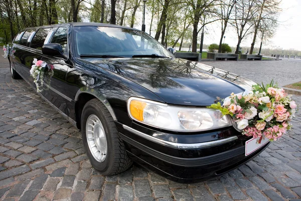 Black Wedding Limousine. Ornated with flowers.