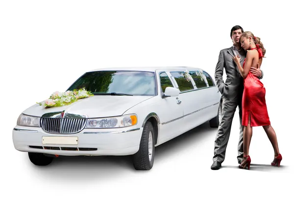 Young beautiful couple with their wedding limousine