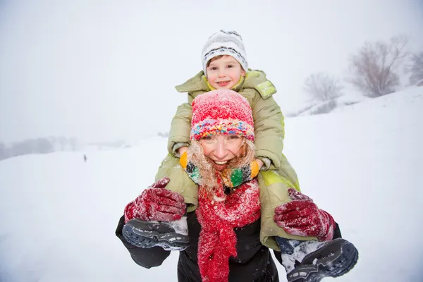 Portrait happy mother and child together in snow laughing, smil