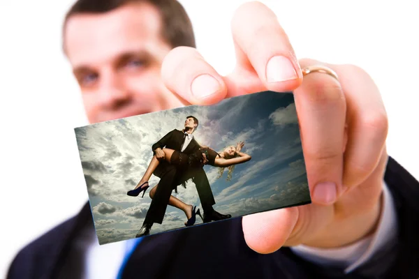 A studio shot of a businessman holding out a blank business card