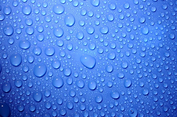 Blue water drops on glass