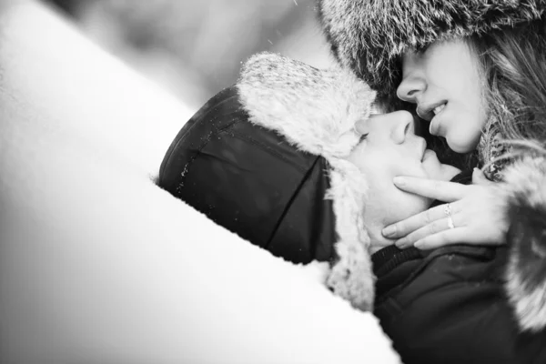 Young couple kissing on snow by chaoss Stock Photo Editorial Use Only