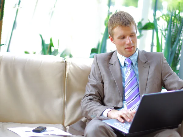 Casual looking businessman working on laptop