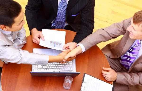 Business handshake over workplace