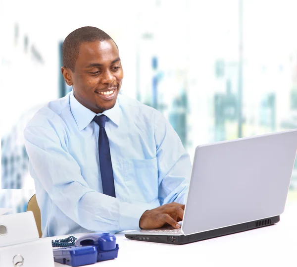 Portrait of a happy African American entrepreneur displaying computer lapto