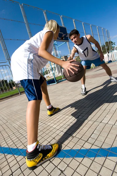 Two young playing basketball