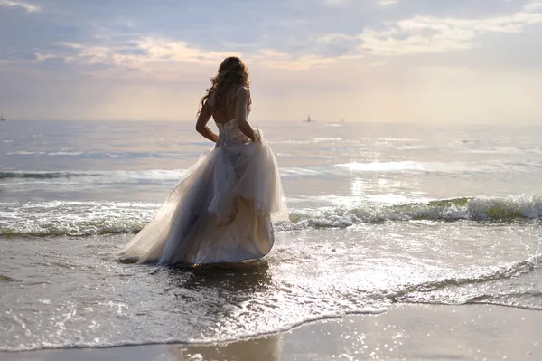 Bride walking along sea coast