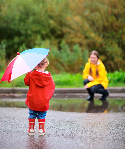 Mother and daughter outdoors at rainy day