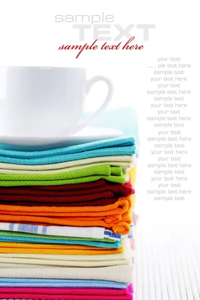 Pile of linen kitchen towels and cup of tea or coffee