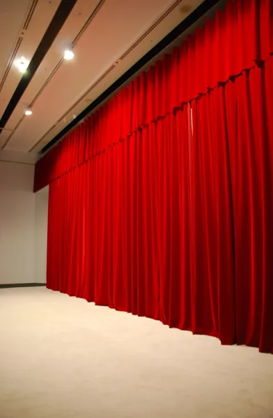 Red draped theater stage curtains with lights