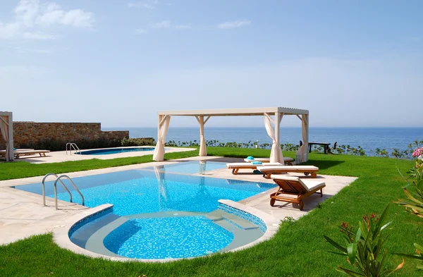 Swimming pool with jacuzzi at the beach of modern luxury villa,