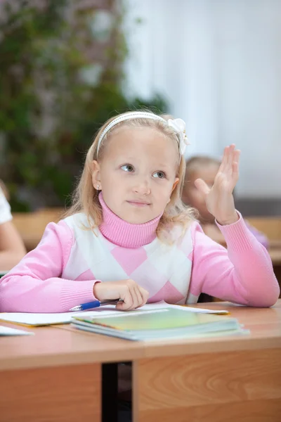 First grader girl puts her hand up