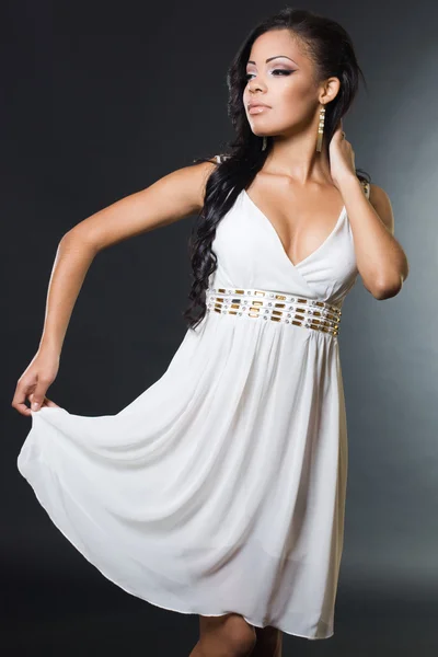 Fashionable mulatto woman in white dress