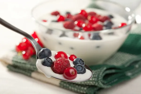 Spoon with yogurt and wild berries