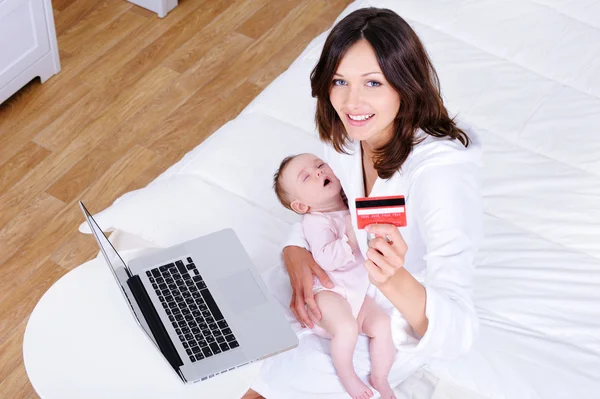 Mother with baby doing internet shopping