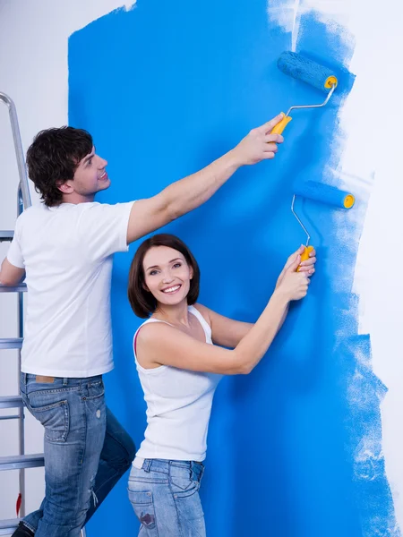 Happy couple painting the wall