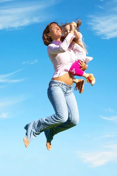 Mother and daughter jumping