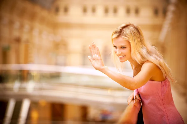 Young woman waves hand