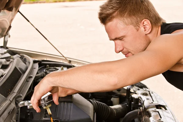 Car mechanician repairs engine