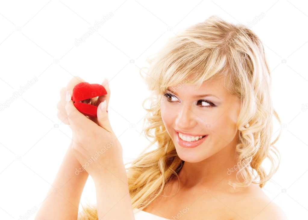 Girl with surprise looks at box with wedding ring isolated on white 