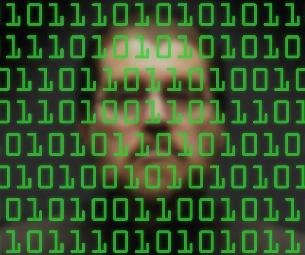 Man monitoring green binary code