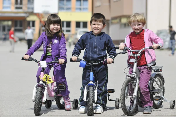 Happy childrens group learning to drive bicycle