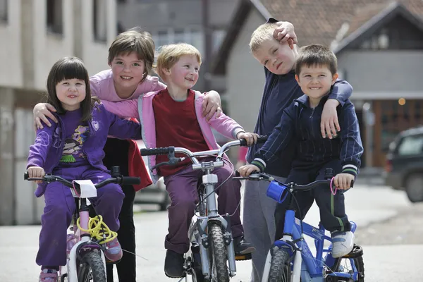 Happy childrens group learning to drive bicycle