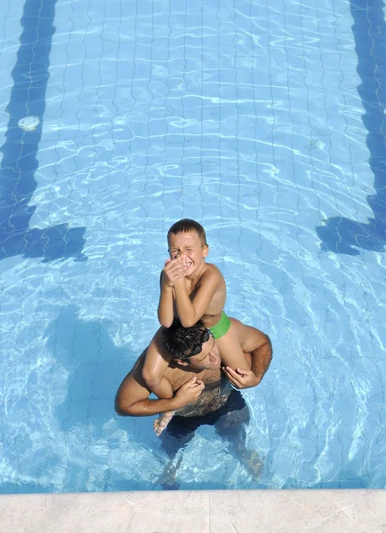 Happy father and son at swimming pool