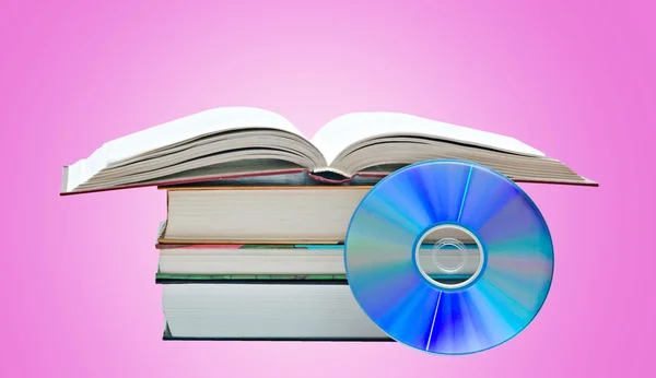 Pile of books, open book, and DVD disk as symbols of old and ne