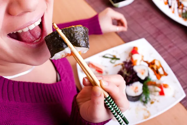 Close up of woman eating sushi