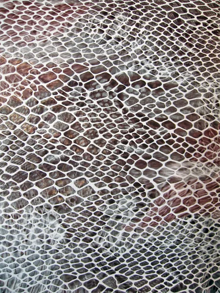 Closeup snakeskin texture, red leathern skin concept.