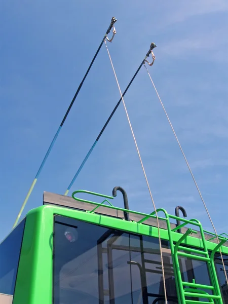 Green trolleybus bars on blue sky, transportation