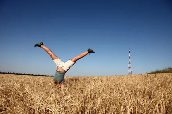Acrobatic girl at field near radio antenna