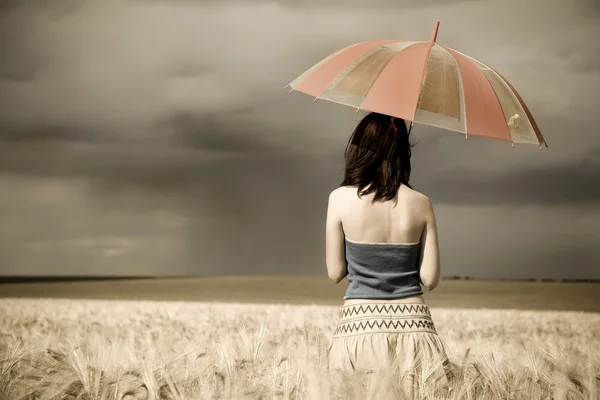 Girl with umbrella at field in retro style