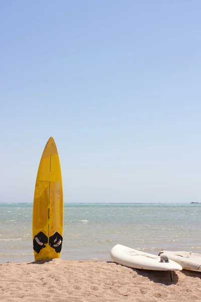 A single surfboard in the sand