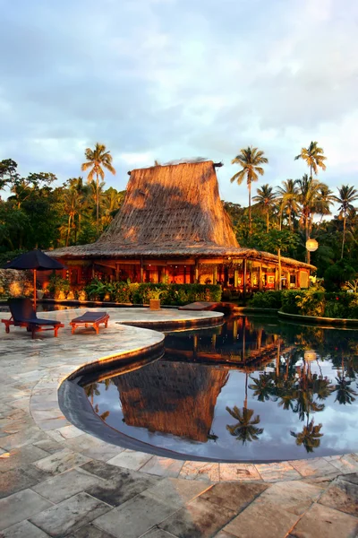 Swimming pool and bar-hut in tropical resort.