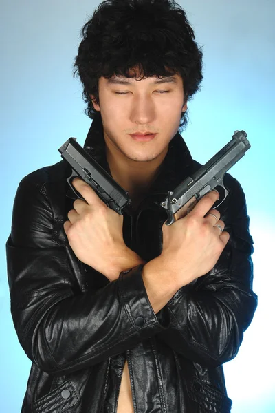 Asian man holding two guns in hands