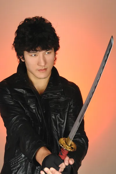 Young asian man holding samurai sword
