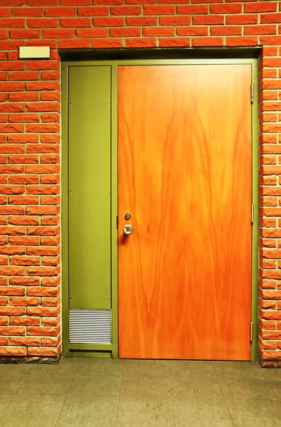 Orange wooden door and bricks