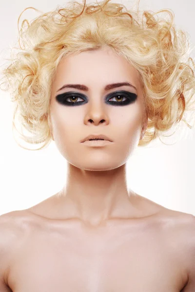 Woman with curly blond hair and black rock evening make-up