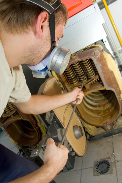 Repair man servicing big gas boiler