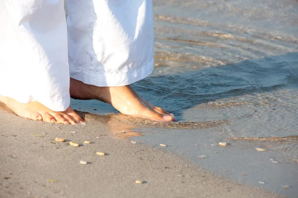 Woman walking barefoot on the beach