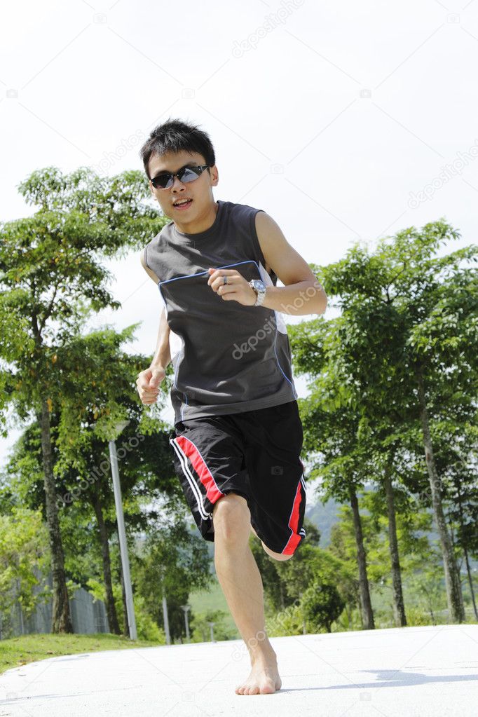 A young Asian man jogging