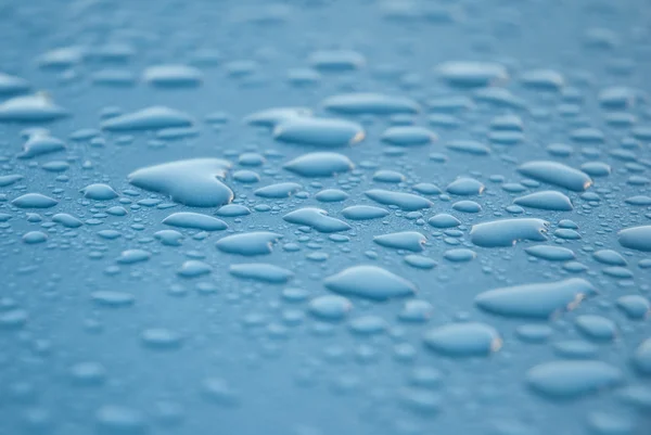Dew drops on blue metallic surface