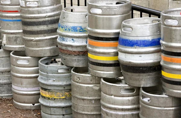 Metal beer kegs stacked up outside of a bar