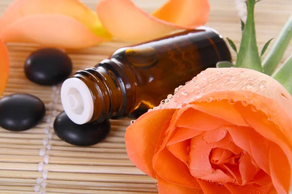 Bottle of essential oil and rose
