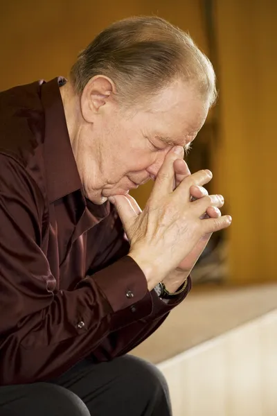 Elderly man praying in church