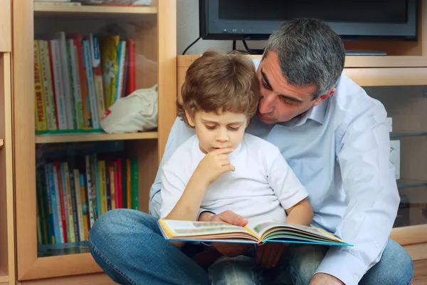 Man and little boy reading book